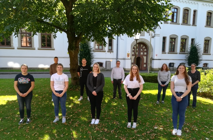 Zeigt die Ausbildungsleiterin und die Gruppe der Anwärterinnen und Anwärter vor dem Auricher Schloßgebäude