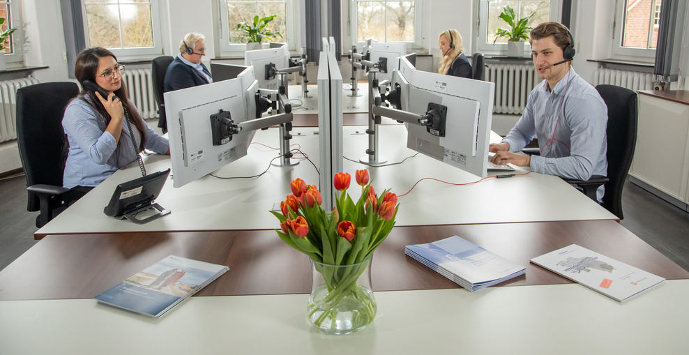 Mehrere Menschen am Computer telefonieren